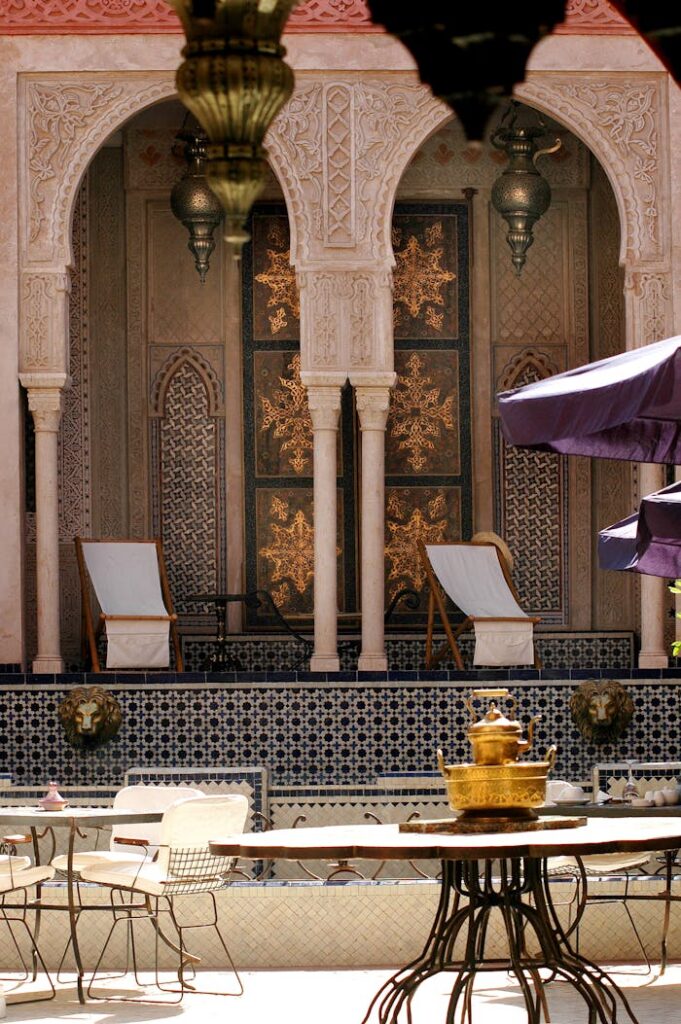 Intricate Moroccan courtyard with traditional architecture and luxury lounge seating at a sunset riad