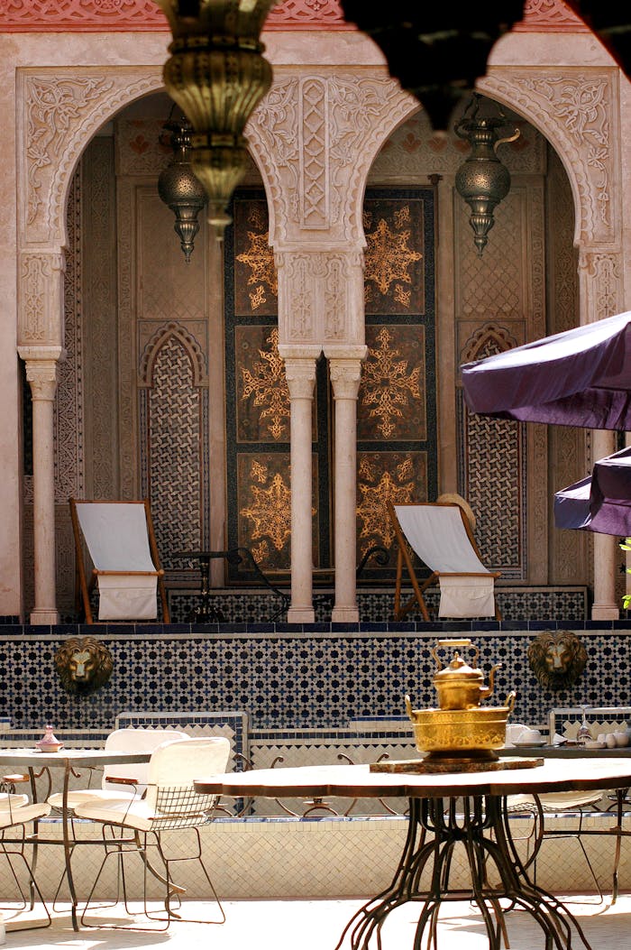 gallery-5 Stunning Moroccan courtyard with intricate designs and relaxing chairs in Marrakech.