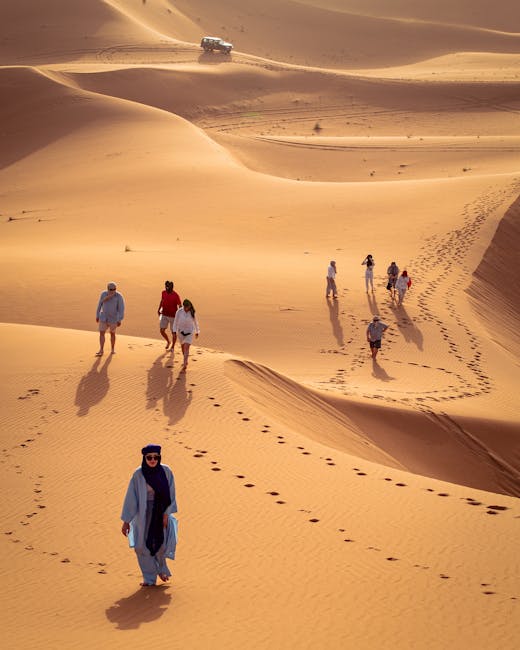 Travelers explore the vast Sahara Desert dunes in Morocco led by a Berber guide.