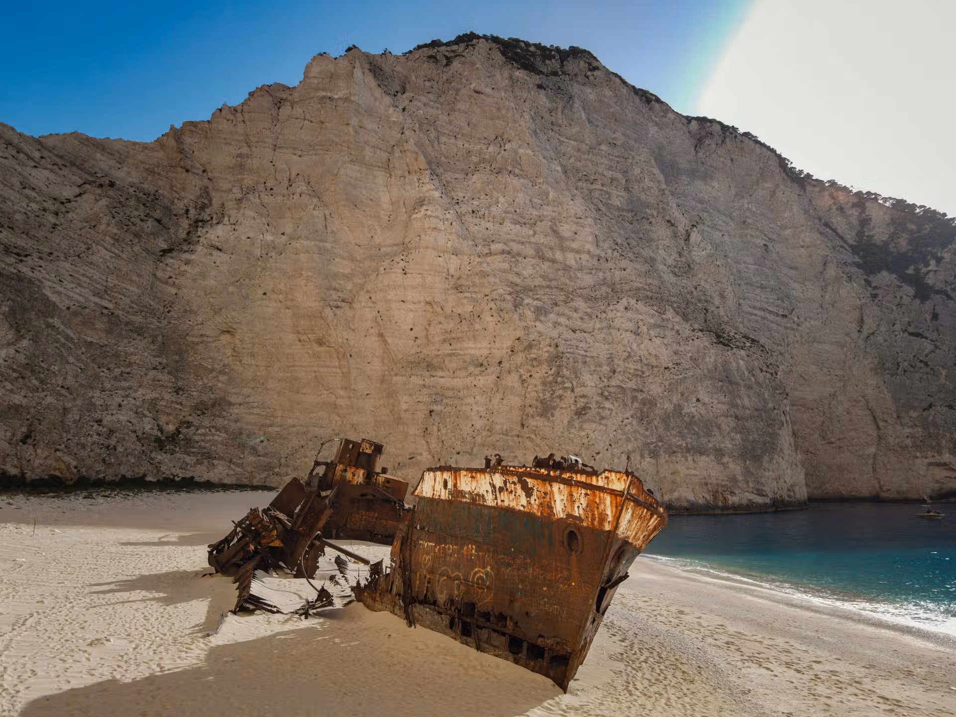 The Shipwreck They Still Can't Explain: The Truth About Navagio Beach Rusted MV Panagiotis shipwreck on the white sand of Navagio Beach, Zakynthos, framed by towering limestone cliffs and turquoise water