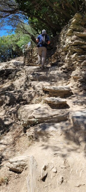 Hiker on the Sentiero Azzurro stone trail in Cinque Terre, Italy
